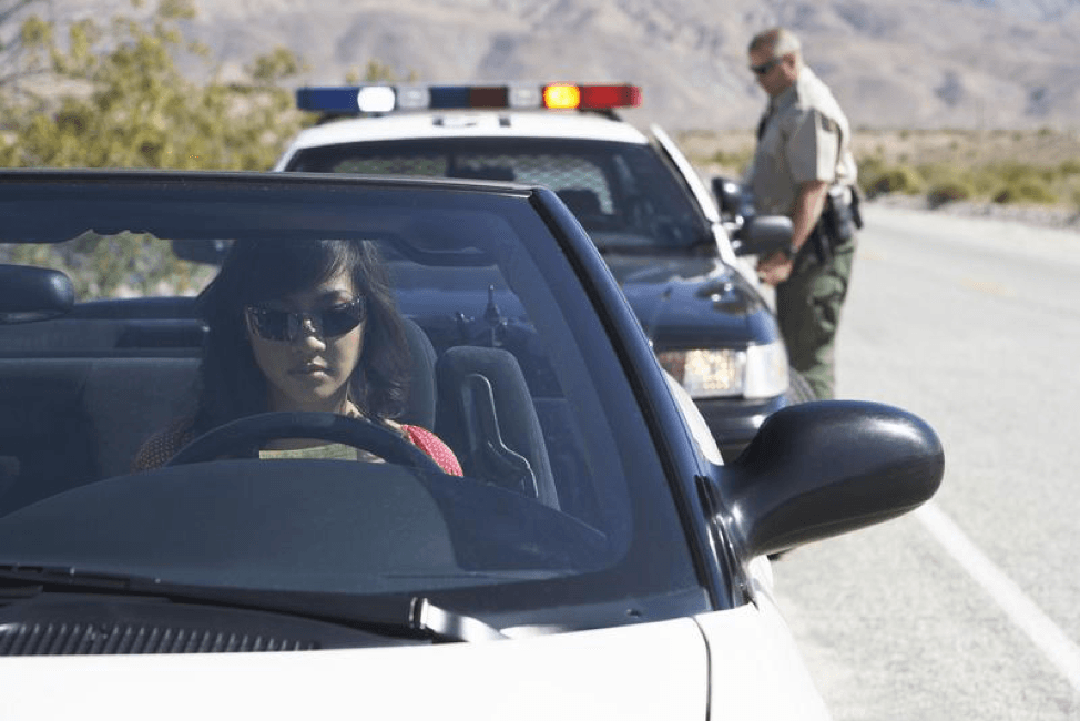 A police officer is talking to a woman in a car